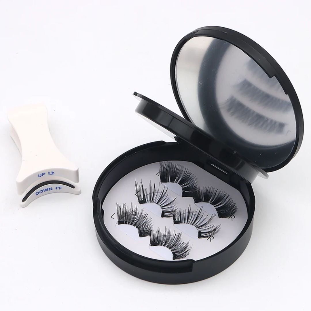 Three pairs of black false eyelashes in an open round black case with a mirror, shown on a white background with a white eyelash extension clip.