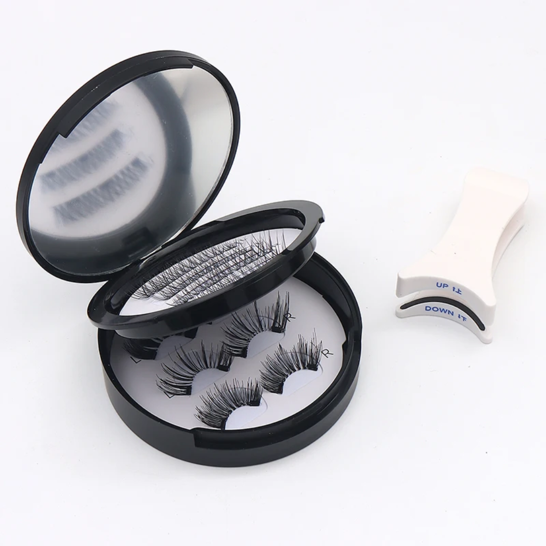 Three pairs of black false eyelashes in an open round black case with a mirror, shown on a white background alongside a white plastic eyelash lifting tool.