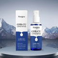 A bottle and box of Hoegoa GHK-CU Copper Peptide Hair & Scalp Serum, 2,400 mg, displayed on a round pedestal with a mountain backdrop.