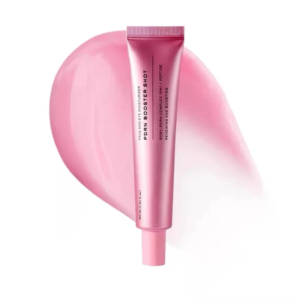 Pink squeeze tube of PORN BOOSTER SHOT cosmetic product centered over a soft pink smear on a white background.