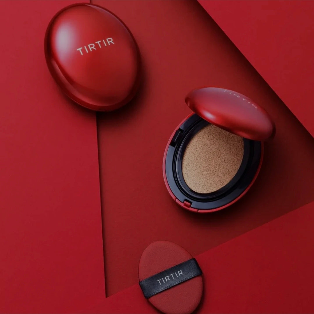 TIRTIR cushion foundation shown in a matte red compact with the compact case, open puff, and cushion pan arranged on a matching red geometric background.