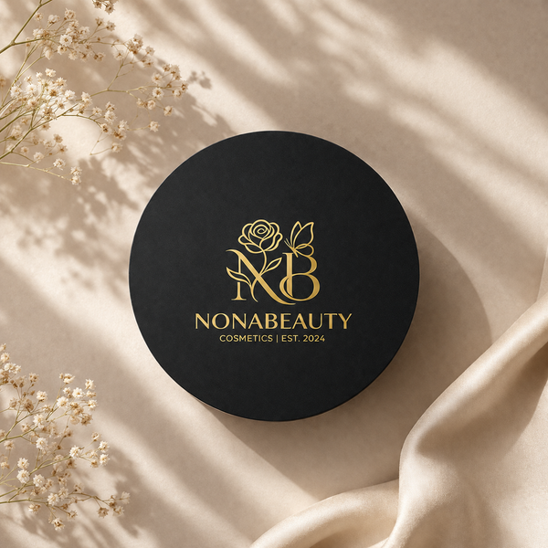 A round black cosmetic box lid with gold Nonabeauty branding, styled on a beige fabric background with dried flowers and soft shadows.